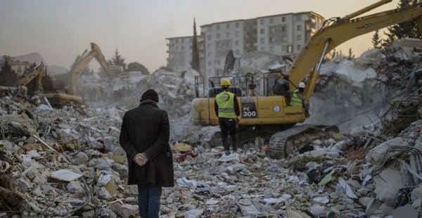 A man stands on top of the rubble of his house destroyed during an earthquake in Antakya, southeastern Turkey.