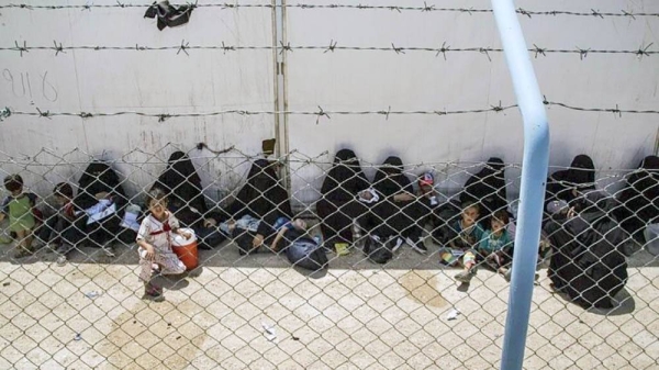 Women and children related to fighters of the Daesh (so-called IS) group wait to board buses and trucks to their homes on June 3, 2019.