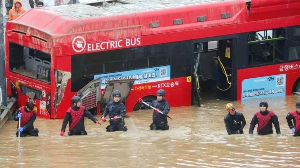 Rescue workers pictured in front of a bus take part in a search and rescue operation near a tunnel. — courtesy Reuters