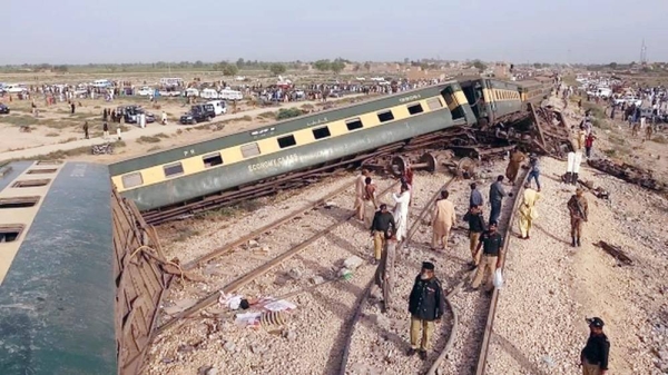 Police officials inspect the carriages at the accident site following the derailment of the train in Nawabshah on Sunday. — courtesy AFP