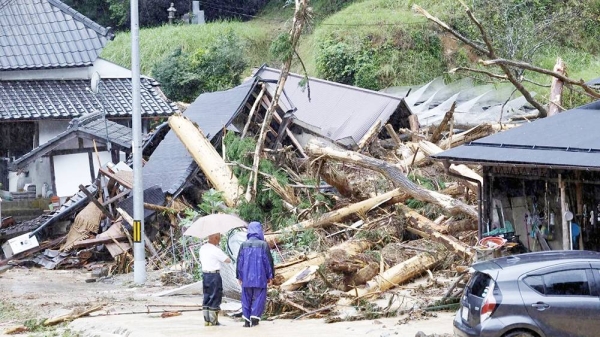 Local residents look at a landslide site caused by Typhoon Lan in Ayabe, Kyoto prefecture, western Japan, on Tuesday. — courtesy Kyodo/Reuters