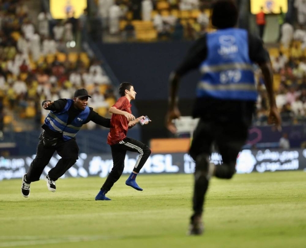 Saudi security men chasing a teenager fan who stormed onto the pitch during Al-Nassr and Al-Taawoun match on Friday. 