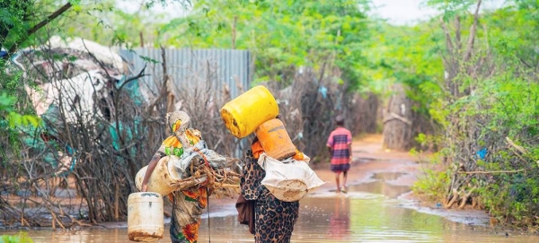 Women walk through the flooded Dadaab refugee camp in northeastern Kenya. — courtesy UNHCR/Mohamed Maalim