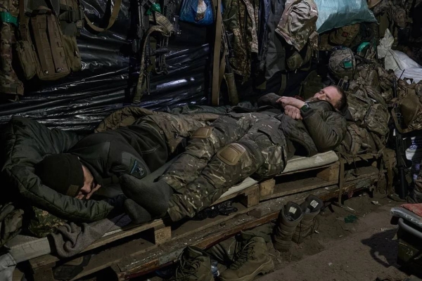 Soldiers sleep in the dugout as they hold their positions in the snow-covered Serebryan Forest in Donetsk region, in January 2024