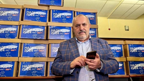 Boris Nadezdhin standing in front of boxes with 105,000 signatures collected in support of his presidential bid