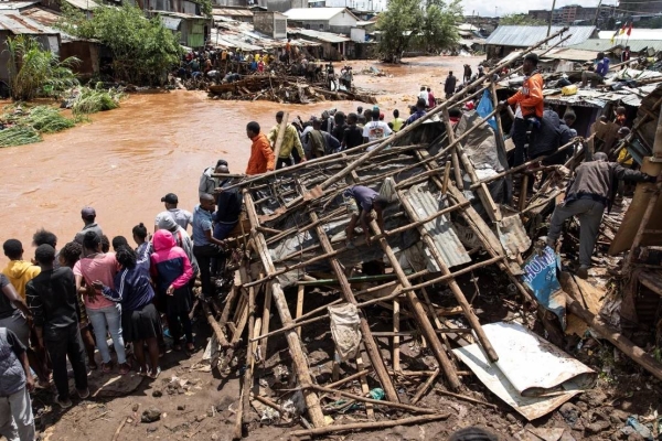 Residents of Mathare stand next to their destroyed houses by the Mathare river, following heavy rains in the capital, Nairobi, on April 24