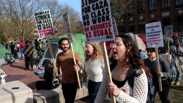 Students marching and holding signs at a rally at University of Michigan. — courtesy Reuters