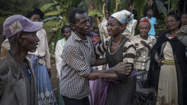 A man and a woman react while residents and volunteers leave for the night after digging in the mud in search for survivors and bodies at the scene of a landslide in Gofa on July 24, 2024