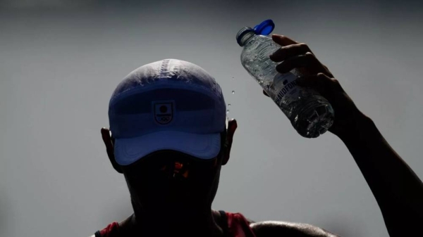 Ryuta Arakawa, of Japan, cools himself off ahead of the men's single sculls rowing quarterfinal at the 2024 Summer Olympics