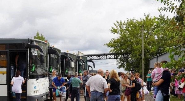 A photo provided by the government of Russia's Kursk region shows people from the border districts of the region boarding evacuation buses