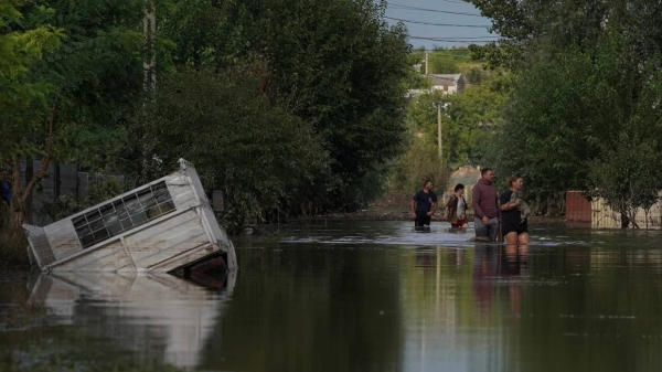 People walk on a flooded road after heavy rain triggered flooding in Cuza Voda, Galati county, Romania, September 15, 2024