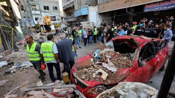 People at the site of an Israeli air strike in Beirut's southern suburbs in Lebanon on Tuesday