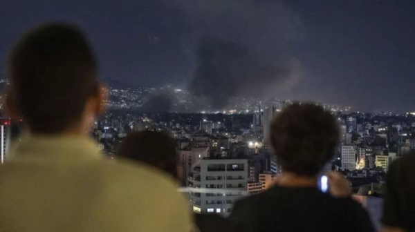 People watched from a distance new Israeli air strikes on Beirut in the early hours of Tuesday