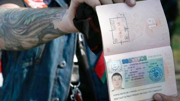 Belarusian biker shows his cancelled visa after returning from Polish border check point in Brest, 27 April 2015 (File)