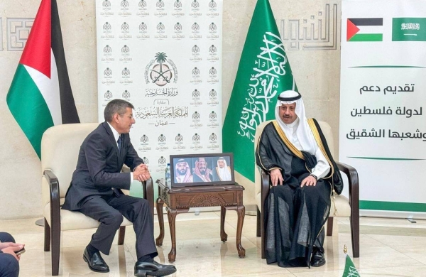 Naif Al-Sudairi, Saudi ambassador to Jordan, non-resident ambassador to Palestine, and consul general in Jerusalem, hands over the monthly financial aid to Finance Minister of Palestine Omar Bitar.