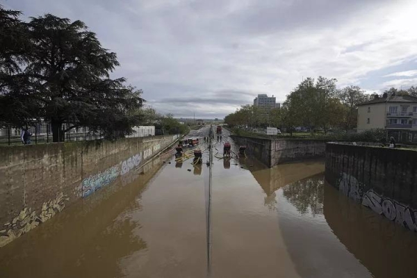 Firefighters pump out water in Givors, central France, after torrential rains and flooding submerged roads and railways.