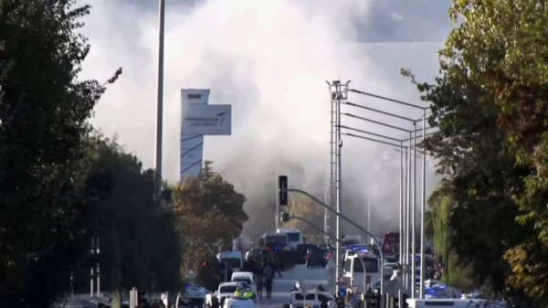 Smoke raises as emergency rescue teams and police officers attend outside Turkish Aerospace Industries Inc. on the outskirts of Ankara, 23 October 2024 -