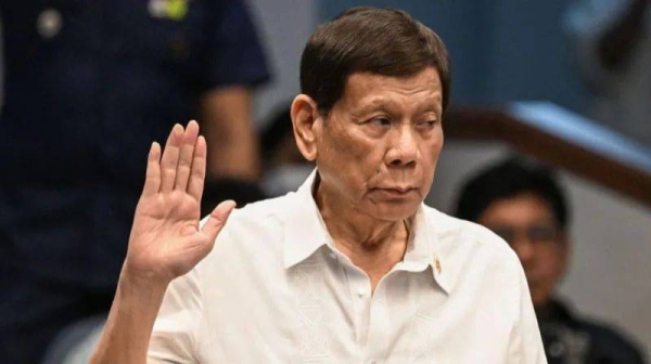 Former Philippine president Rodrigo Duterte takes an oath as he attends a senate probe on the drug war during his administration