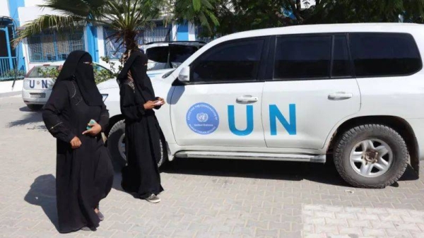 Palestinian women walk past a UN vehicle at an Unrwa centre in Khan Younis