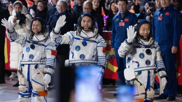 Astronauts (L-R) Wang Haoze, Song Lingdong and Cai Xuzhe wave before the launch