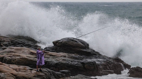 A man goes fishing near high waves as Typhoon Kong-rey approaches in Keelung in the northeastern part of Taiwan on October 29, 2024