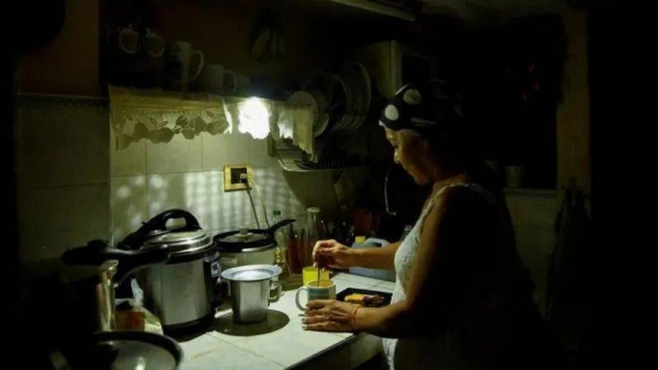 Havana resident Araselys Rodriguez makes coffee during the blackout