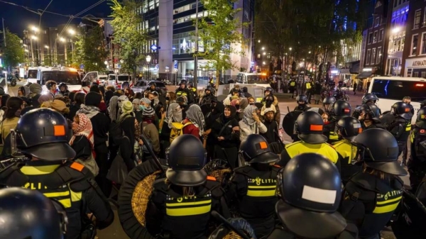 Detained pro-Palestinian demonstrators wait to be bused away following a pro-Israeli commemoration marking the anniversary of the October 7, 2023, Hamas attack, in Amsterdam