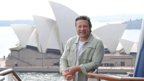 Jamie Oliver stands in front of the Sydney Opera House
