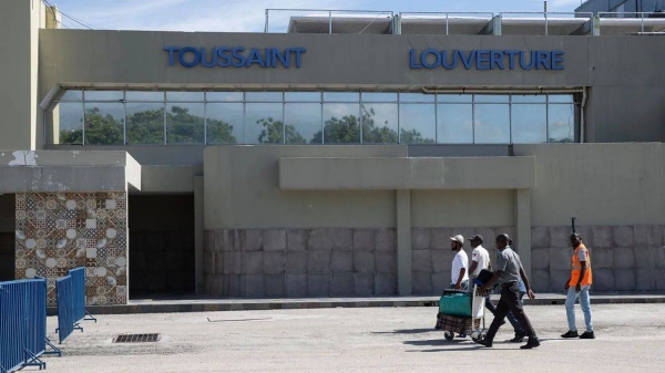 Travellers walk in front of the Toussaint Louverture International Airport in Port-au-Prince in May 2024