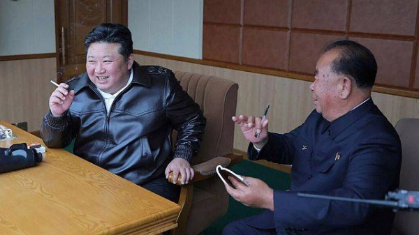 In this photo provided by the North Korean government, its leader Kim Jong Un, left, inspects tests of drones designed to crash into targets, in North Korea