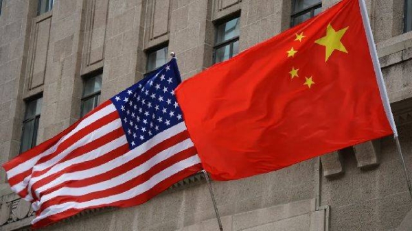 The national flags of the United States and China flutter at the Fairmont Peace Hotel on April 25, 2024 in Shanghai, China