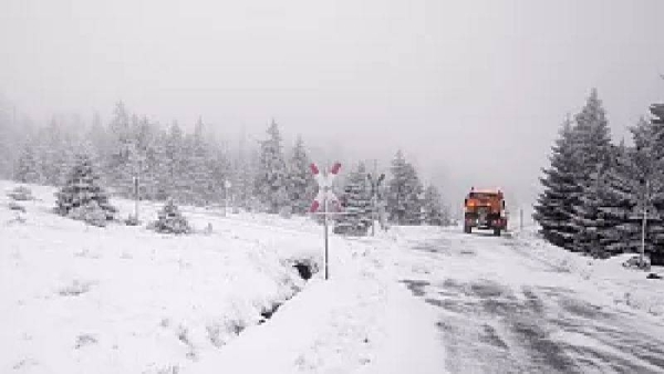 A truck drives along an icy road