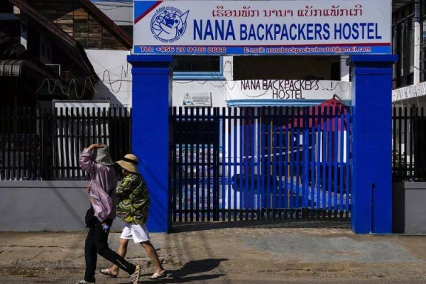 Foreign tourists walk past the closed Nana Backpackers hostel in Vang Vieng, Laos, Saturday, Nov. 23, 2024