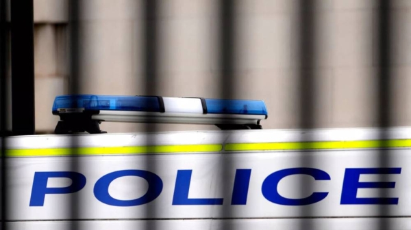 A police van is parked behind railings in Westminster in London, Tuesday, March 21, 2023