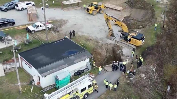 Emergency workers have widened the original hole and opened up a second one to try to access the victim