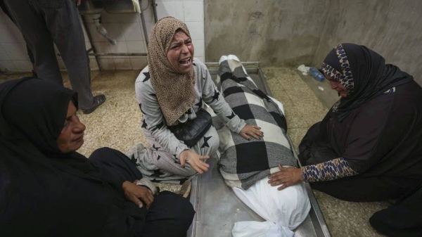 Relatives mourn over the body of 17-year-old Rahaf Abu Laban in Deir al-Balah after she was crushed to death as a crowd of Palestinians pushed to get bread at a bakery