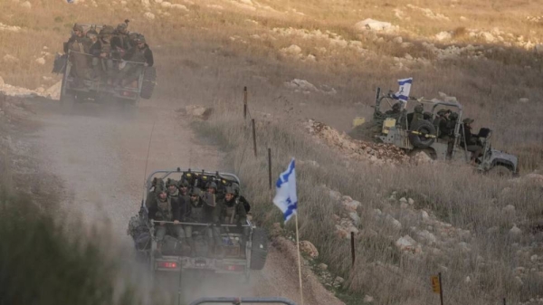 Israeli soldiers cross the security fence moving towards the so-called Alpha Line that separates the Israeli-annexed Golan Heights from Syria, in the town of Majdal Shams