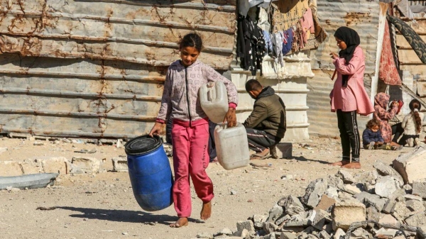 A young girl carries jerry cans in Khan Yunis on December 4