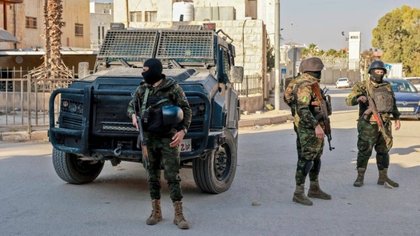 Palestinian security forces stand guard at a roadblock in Jenin following clashes with militants the day before