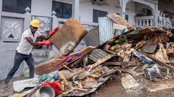 A worker clears debris on a street in the city of Mamoudzou on the French Indian Ocean territory of Mayotte, after the cyclone Chido hit the archipelago