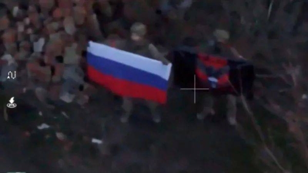 An image taken from social media and supplied by the Reuters news agency appears to show a soldier holding up a Russian flag in Kurakhove