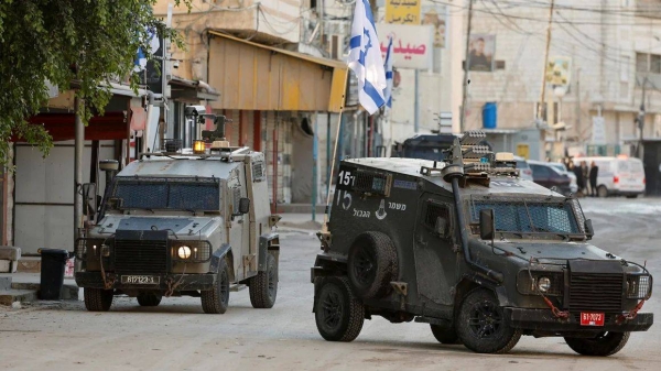 Israeli military vehicles drive on the street during an Israeli raid in Jenin, in the occupied West Bank, on January 21, 2025