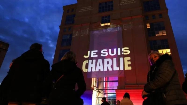 A building draped with a banner stating Je Suis Charlie or We are Charlie.
