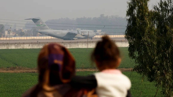 People look at a US military plane deporting Indian immigrants as it lands in Amritsar, India, on Wednesday