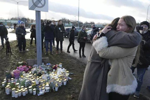 People gather at a makeshift memorial near the scene of a shooting on the outskirts of Orebro, Sweden, Wednesday, Feb. 5, 2025