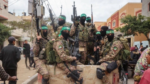 Hamas fighters patrol a street before they handover three Israeli hostages to a Red Cross team in Deir el-Balah, central Gaza, on February 8