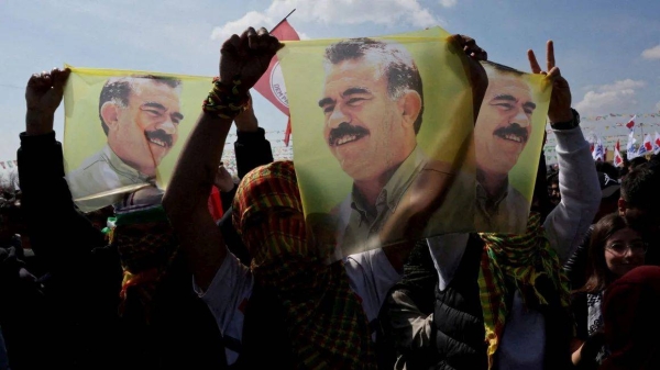 Supporters of pro-Kurdish Peoples' Equality and Democracy Party display flags with a portrait of jailed Kurdistan Workers' Party leader, Abdullah Ocalan, during a rally in Istanbul in March 2024