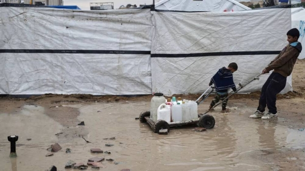 A boy and a child carry water in cans at a tent camp for the displaced whose homes were damaged by Israeli strikes in Zeitoun neighborhood of Gaza City, March 7th 2025