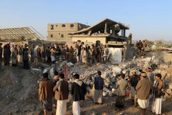 People gather at the site of a house hit by a strike in Saada, Yemen, March 16, on Sunday