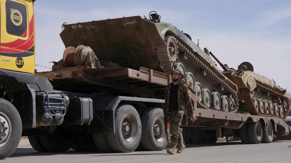 A member of the Syrian forces near a military vehicle as it heads toward the Syrian-Lebanese border in Qusayr, Syria, on Monday